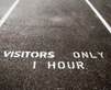 Parking space with visitors only sign.