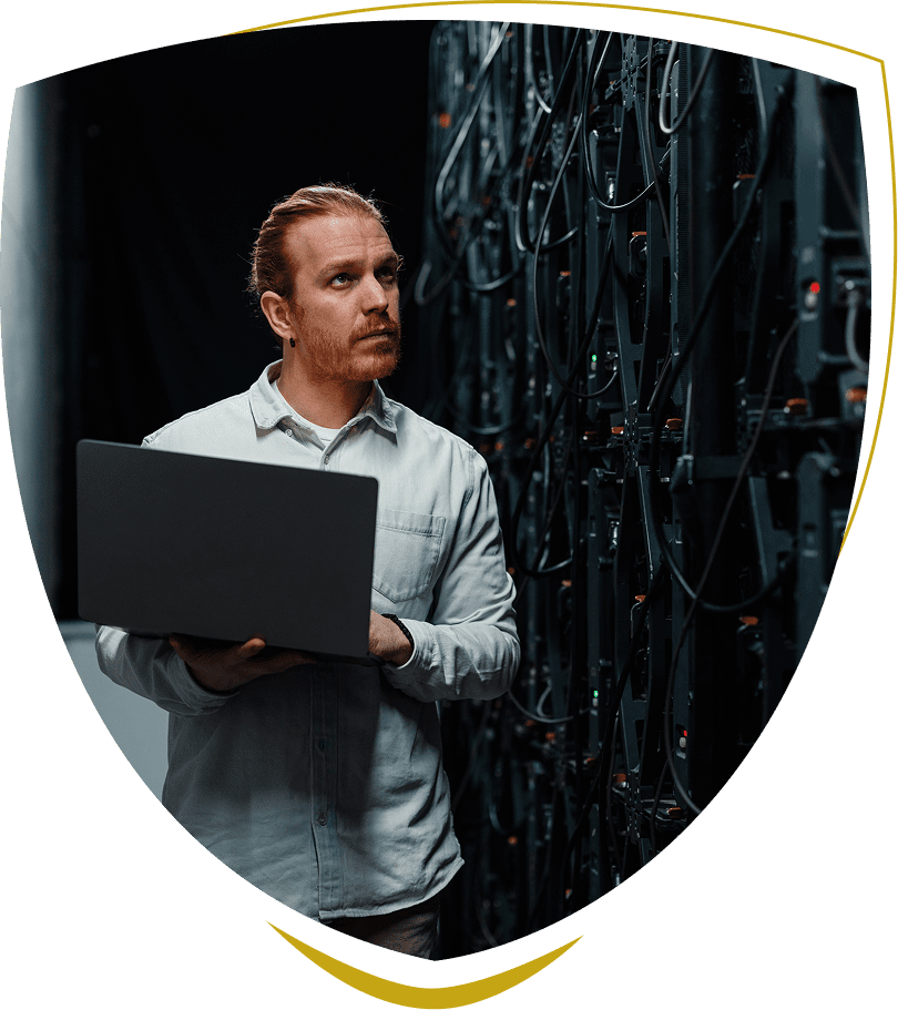 Man with laptop in a server room.
